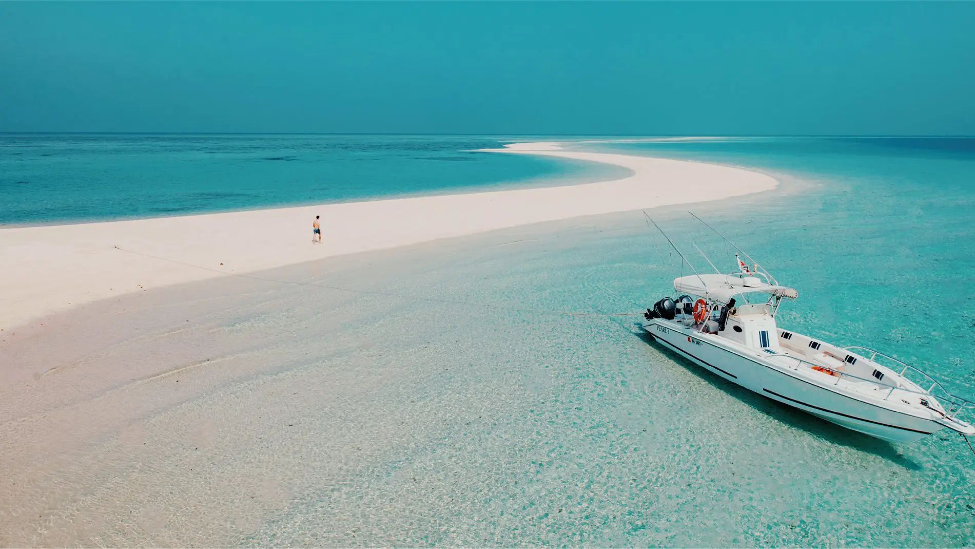 A boat is sitting on a sandy beach in the middle of the ocean.