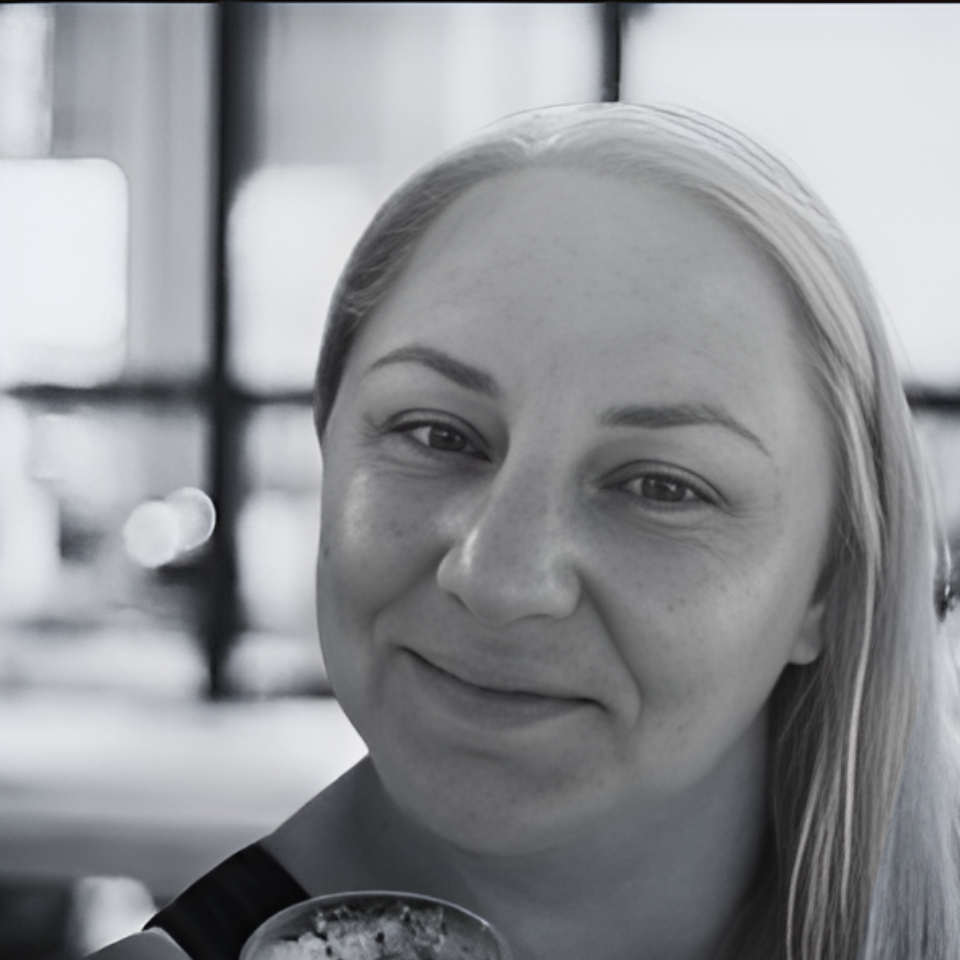 A black and white photo of a woman holding a glass