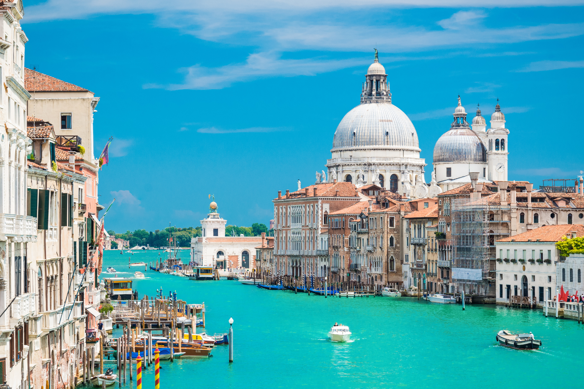 A view of the grand canal in venice with a large dome in the background.