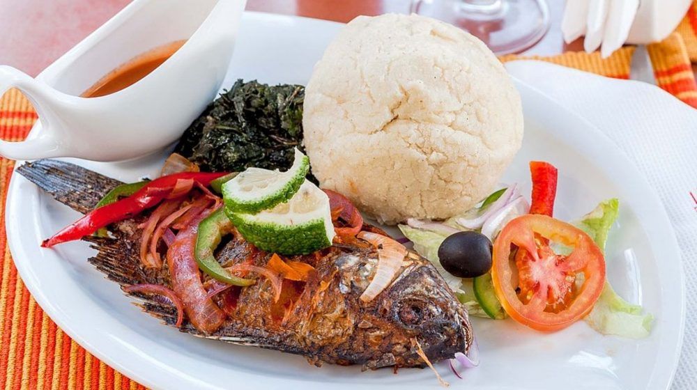 A plate of food with a fish and vegetables on it