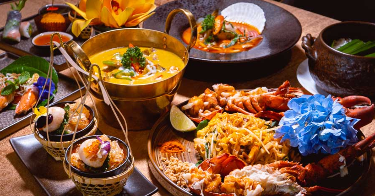 A table topped with plates of food and a bowl of soup.