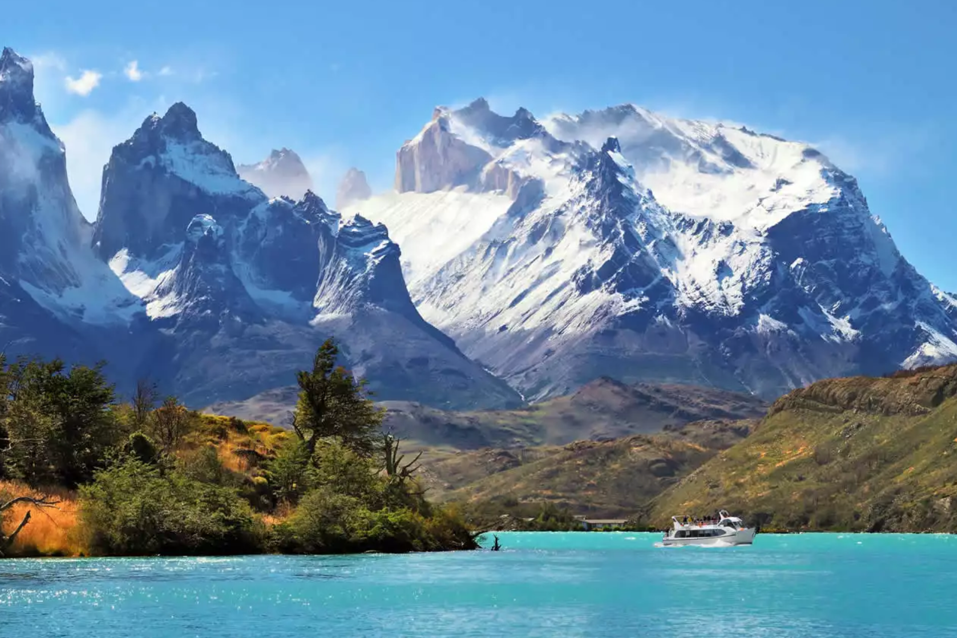 A boat is floating on a lake with mountains in the background.