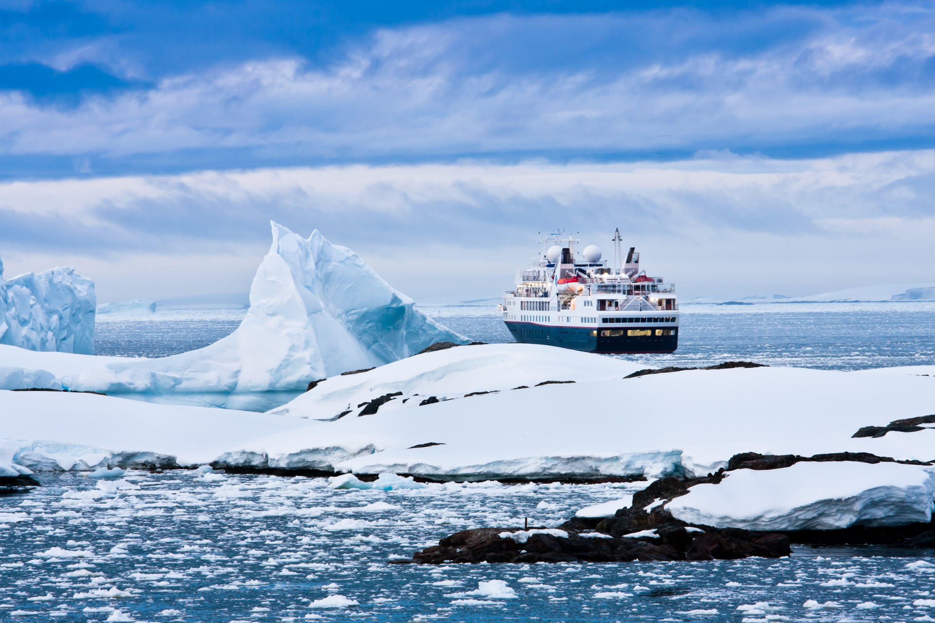 A cruise ship is floating on top of an iceberg in the ocean.