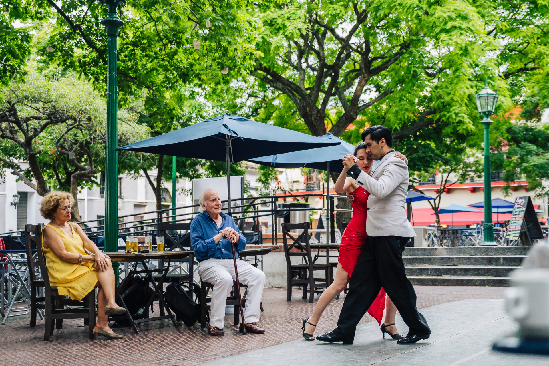 A group of people are dancing tango in a park.