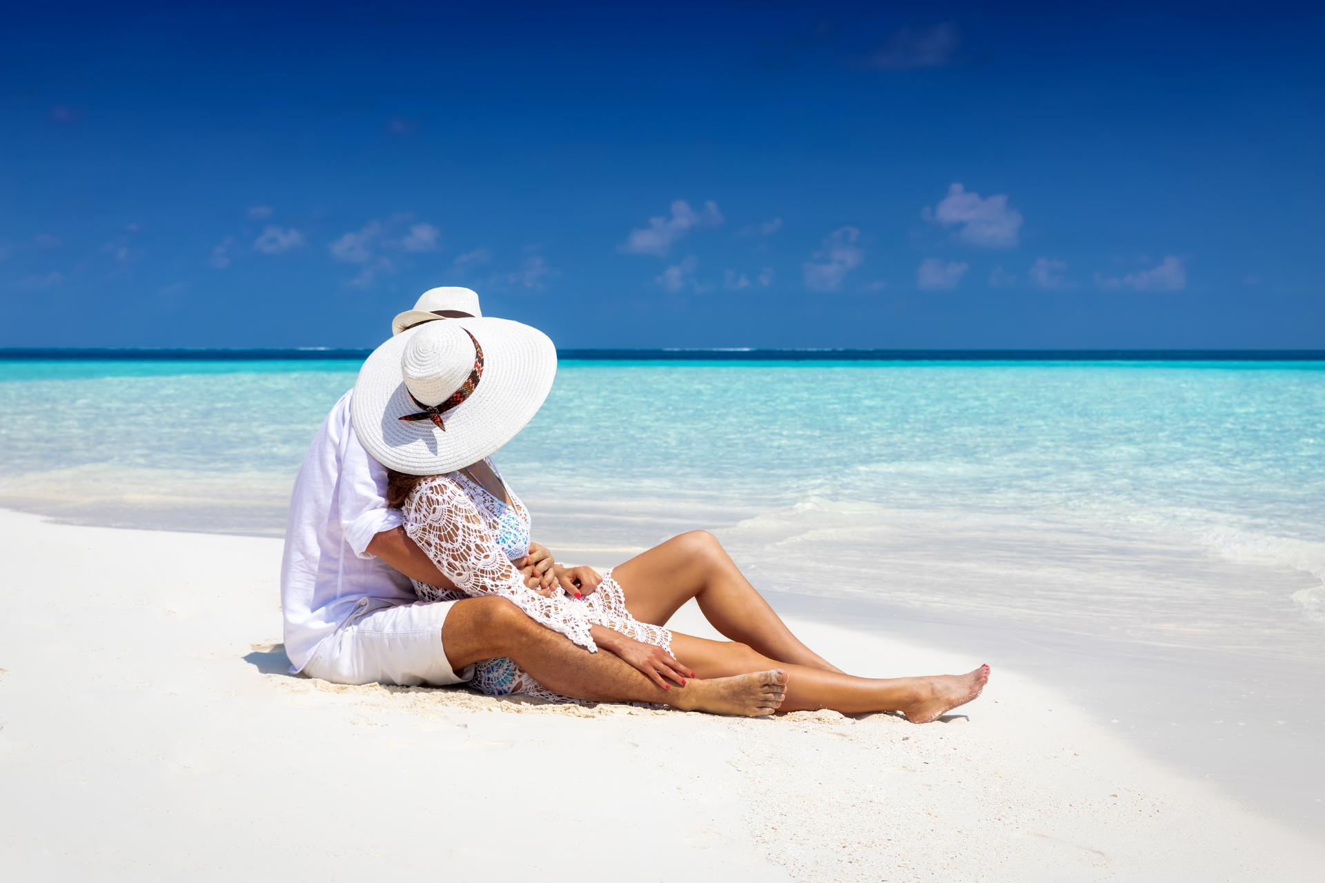 A man and a woman are sitting on the beach.