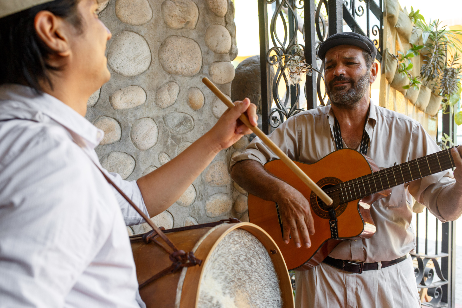 A man playing a drum and another man playing a guitar