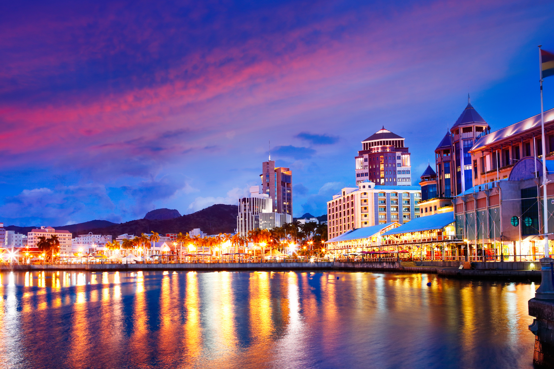 A city at night with a large body of water in the foreground