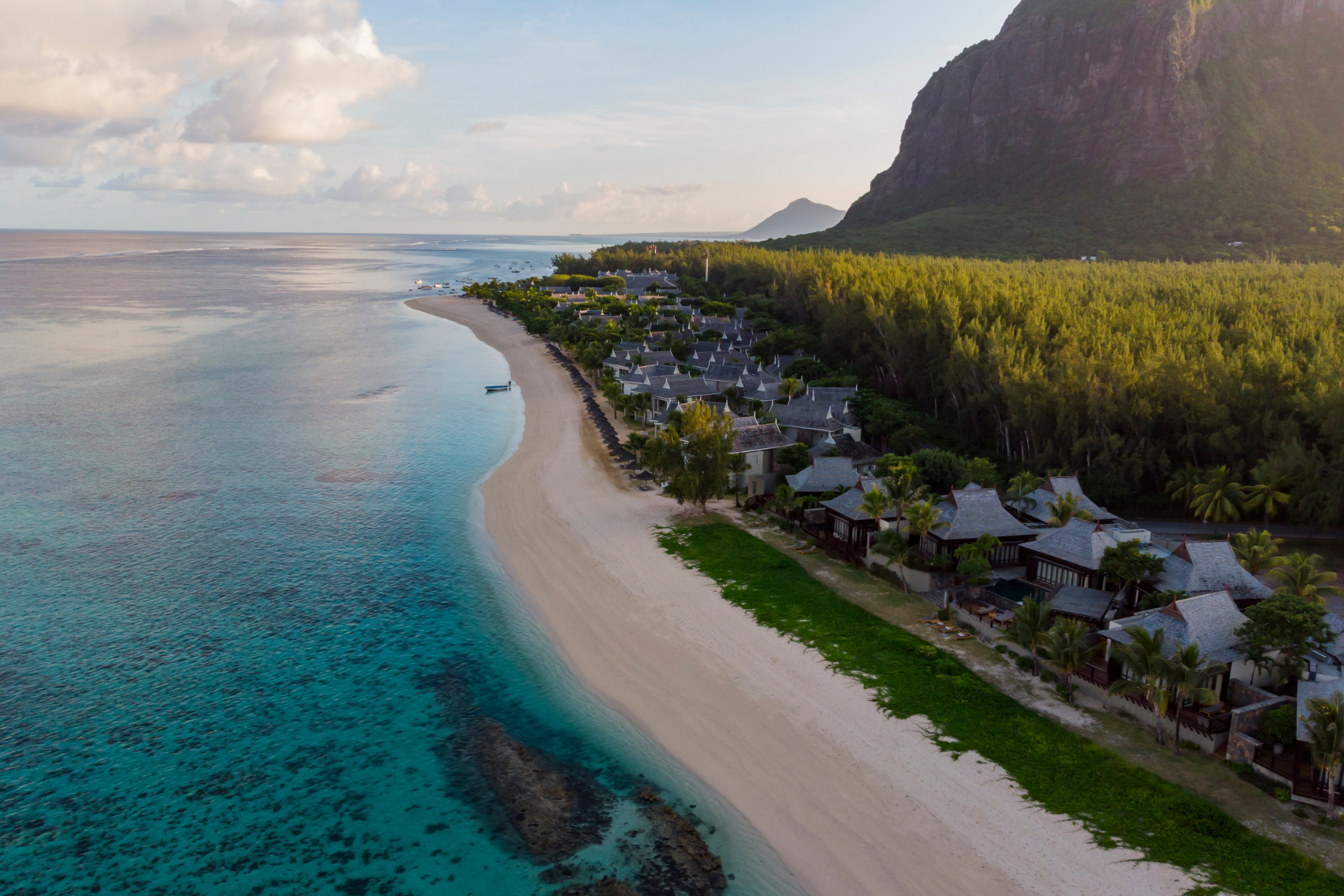 An aerial view of a beach with a mountain in the background.