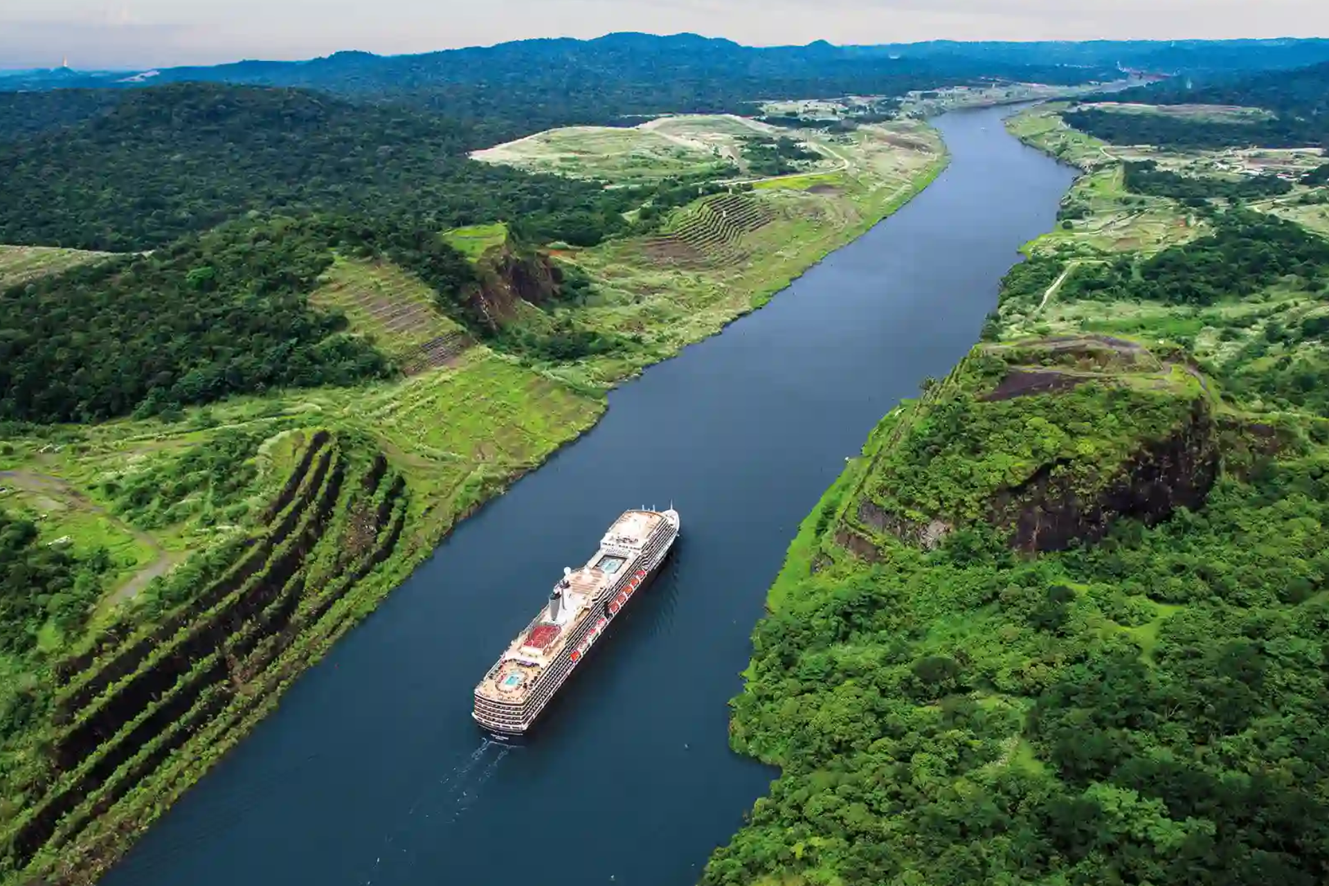 An aerial view of a large ship floating down a river