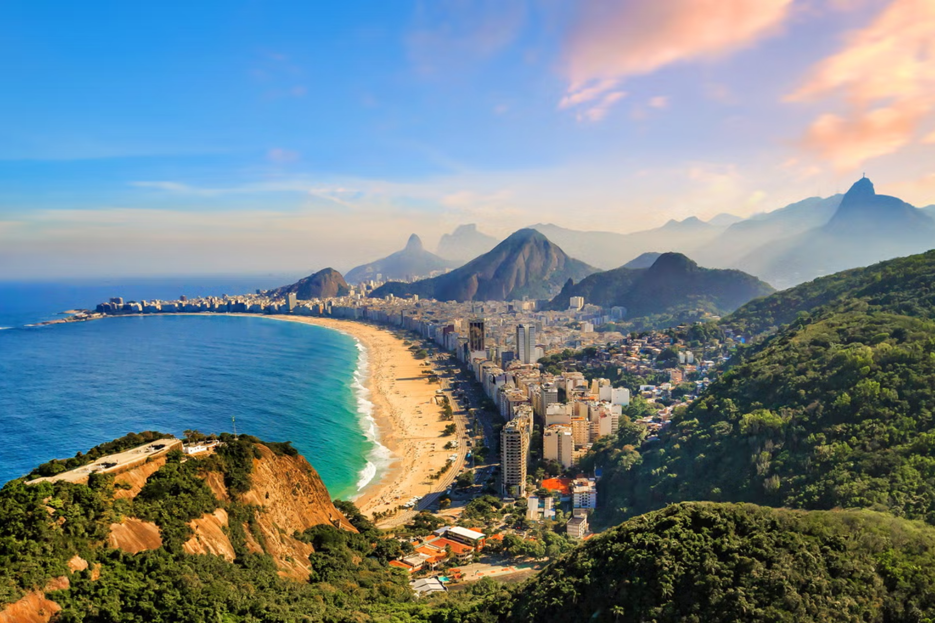 An aerial view of a beach in rio de janeiro with mountains in the background.