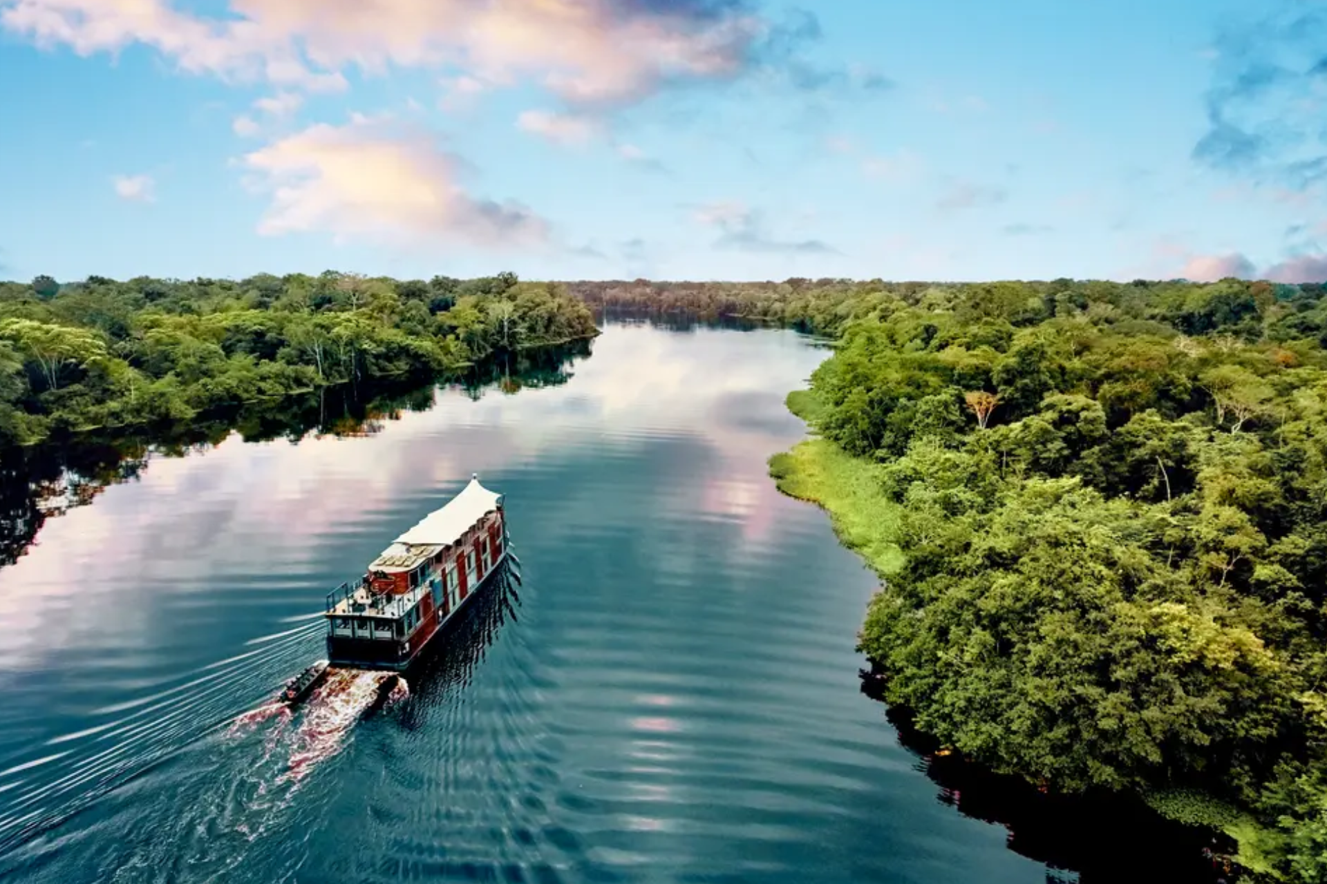 A boat is floating down a river surrounded by trees.