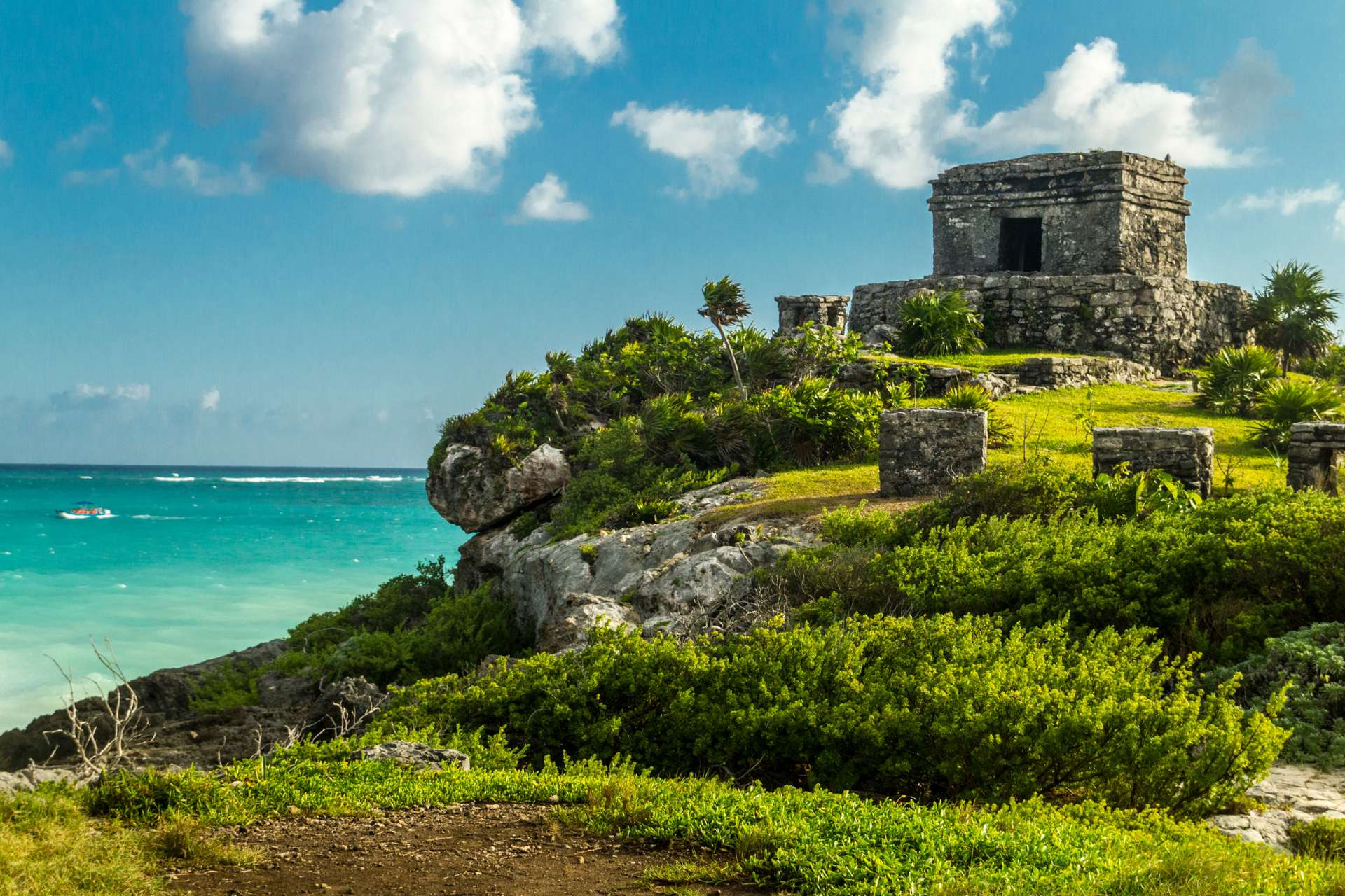 A castle is sitting on top of a hill next to the ocean.