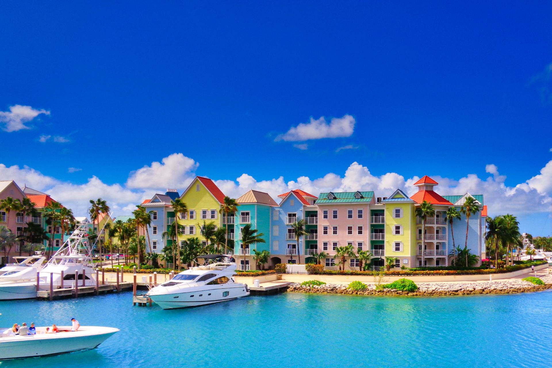 A boat is docked in front of a row of colorful buildings.