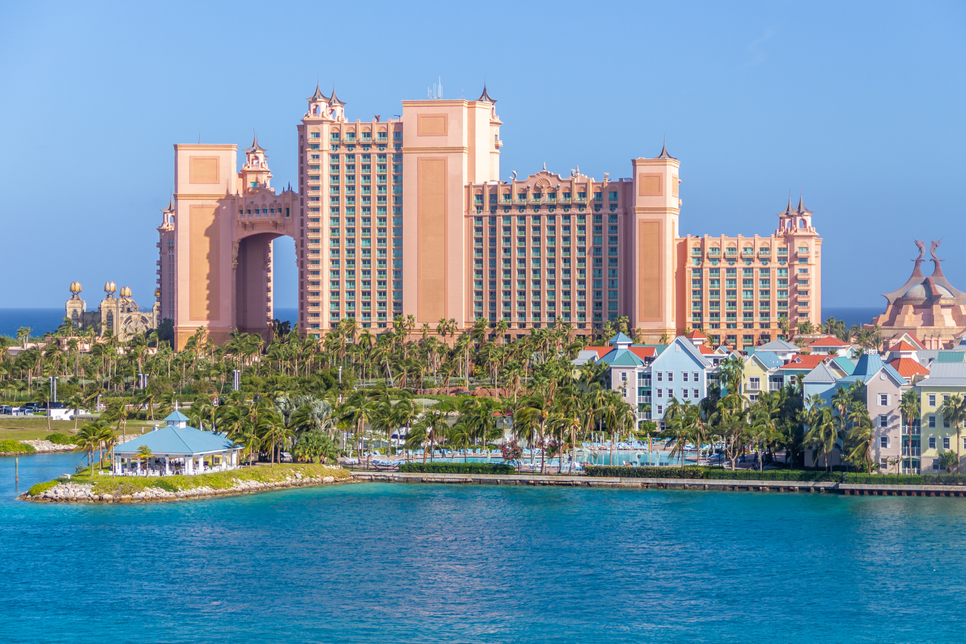 A large building is sitting on top of a small island in the middle of the ocean.