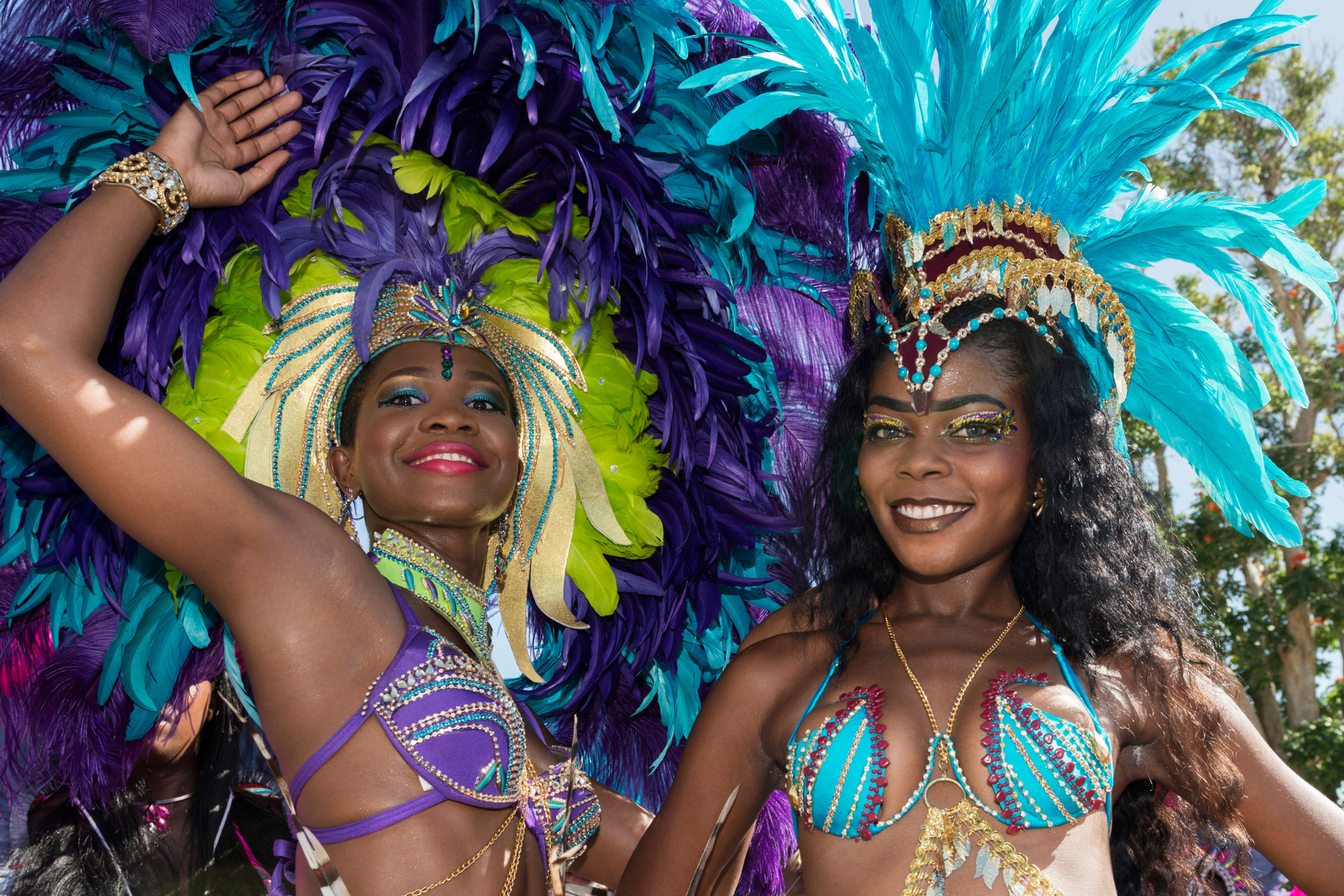 Two women in colorful costumes are posing for a picture.