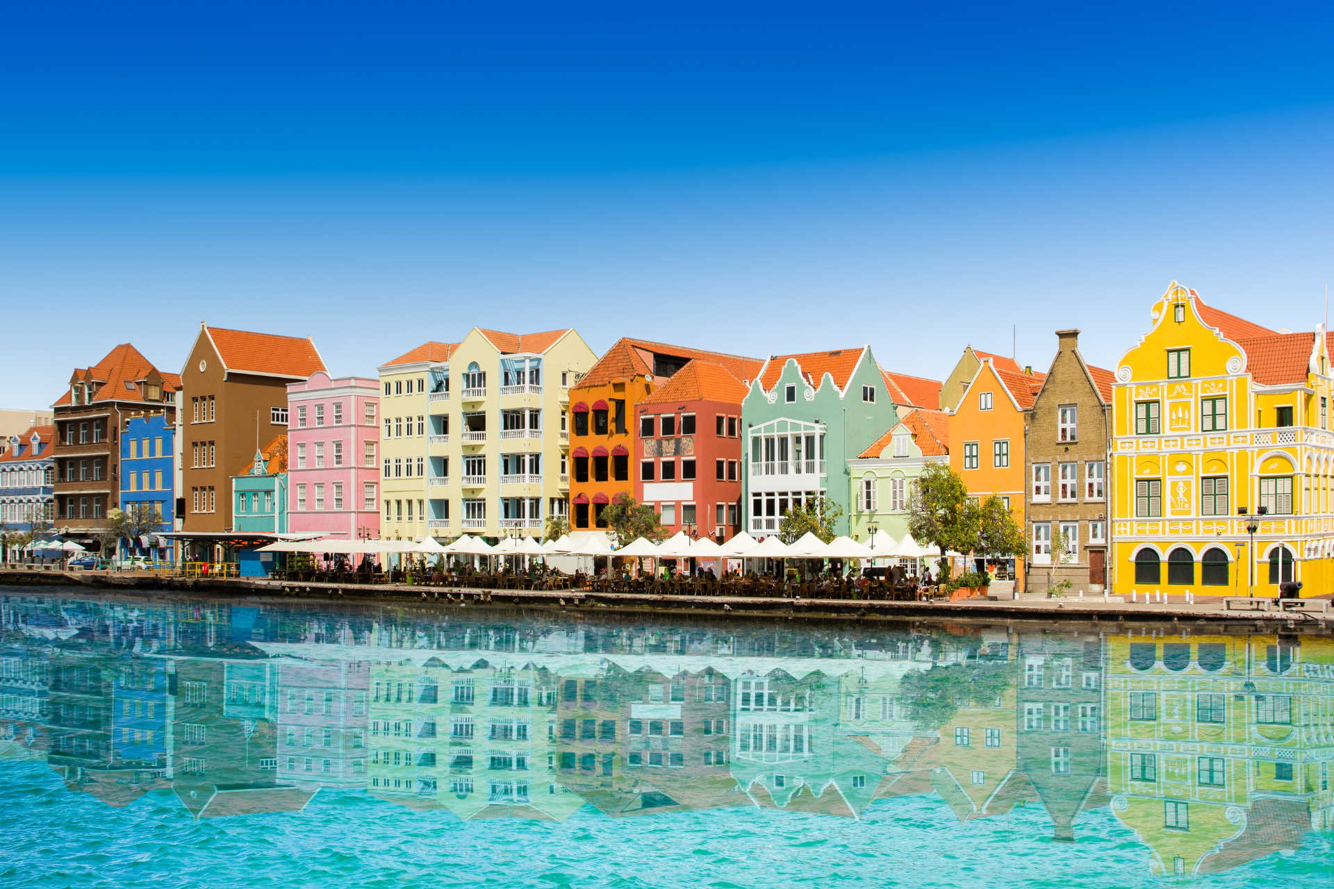 A row of colorful buildings next to a body of water.