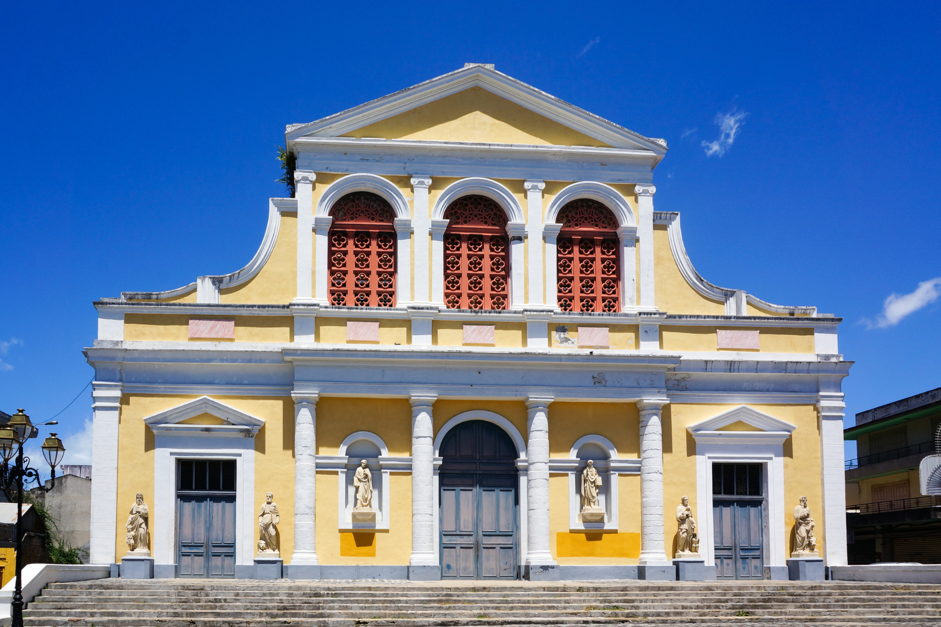 A large yellow and white building with a blue sky in the background.