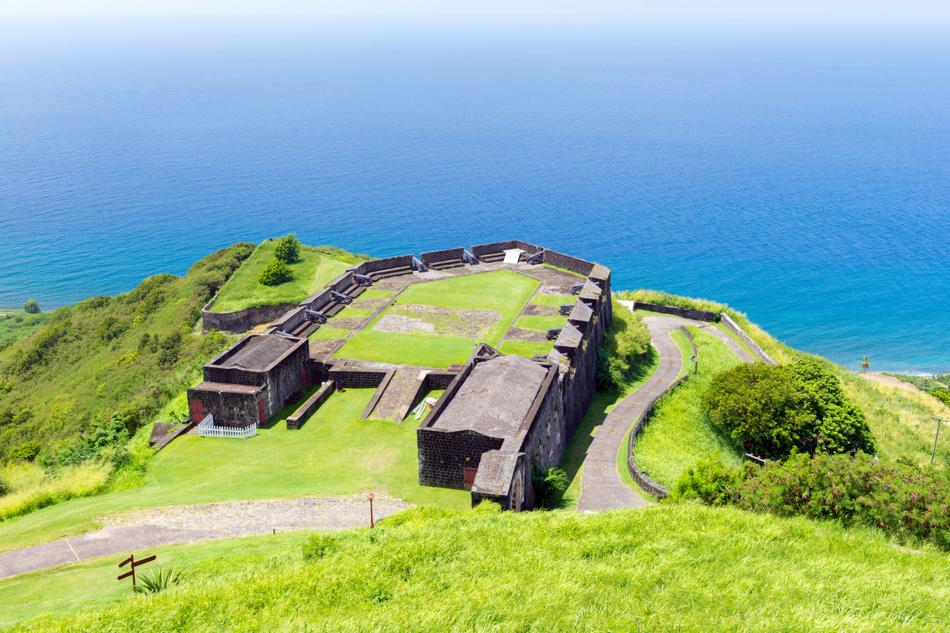 An aerial view of a castle on top of a hill overlooking the ocean.