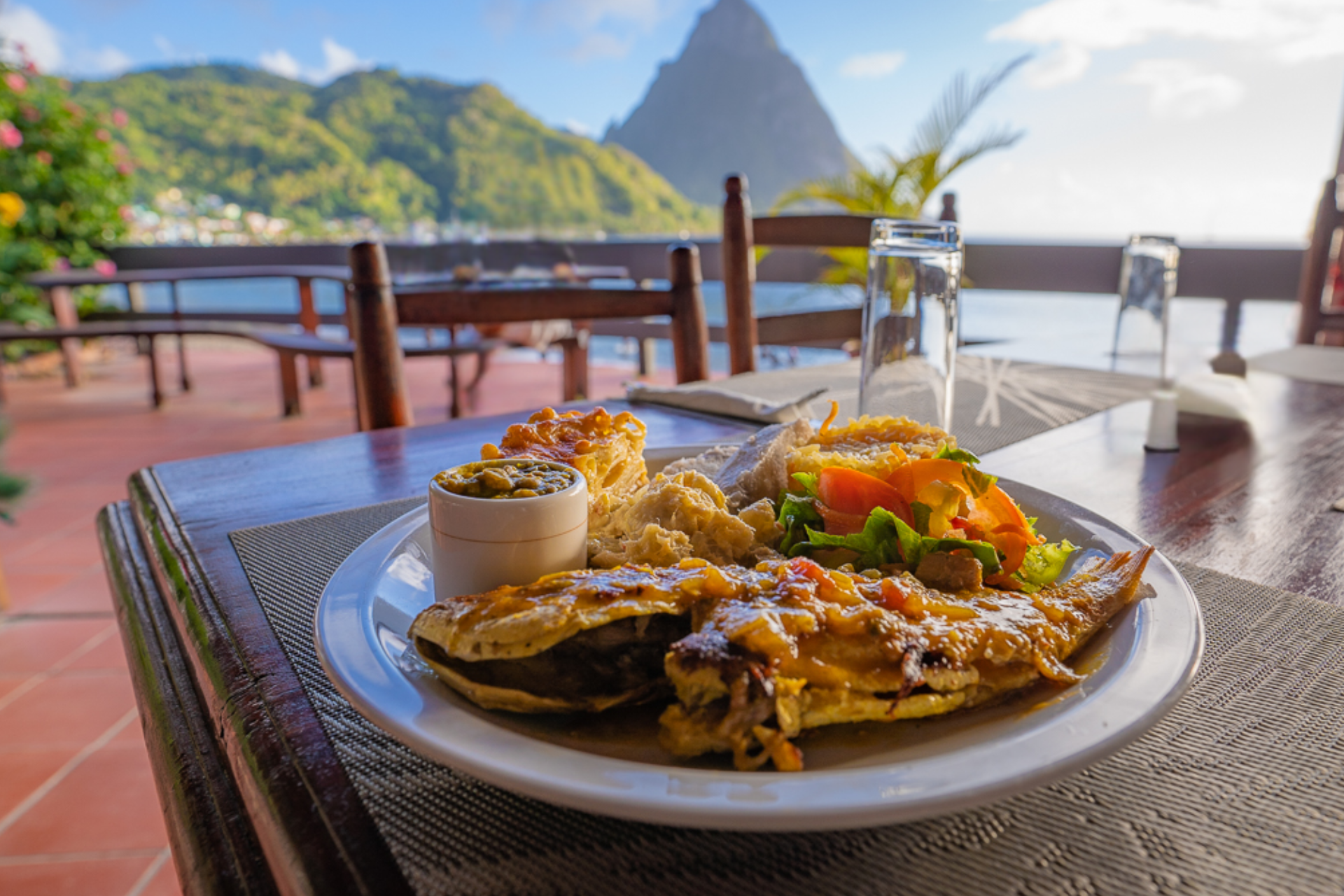 A plate of food is sitting on a table with a mountain in the background.