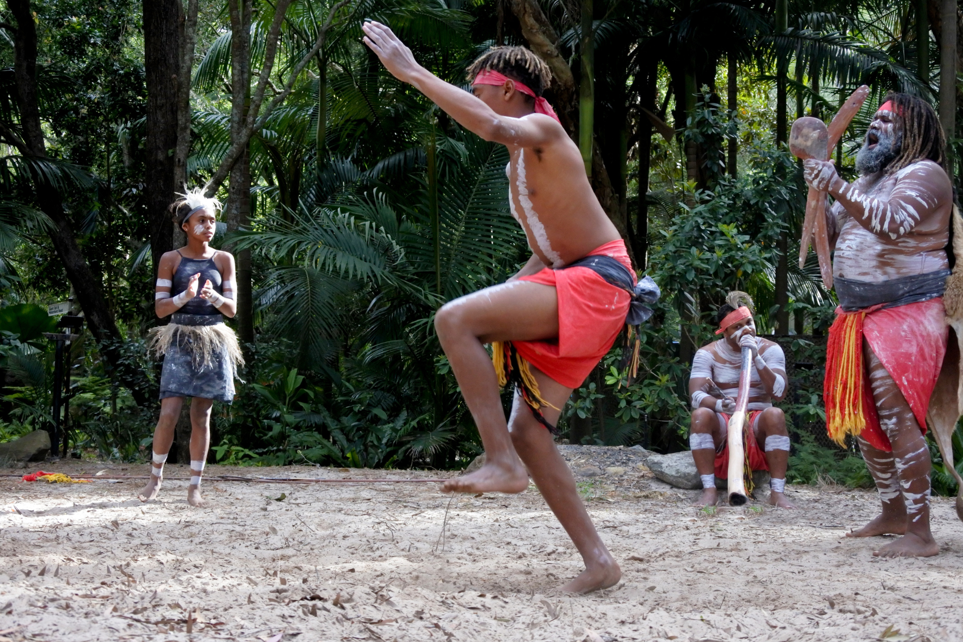 A man is jumping in the air while a group of people watch.