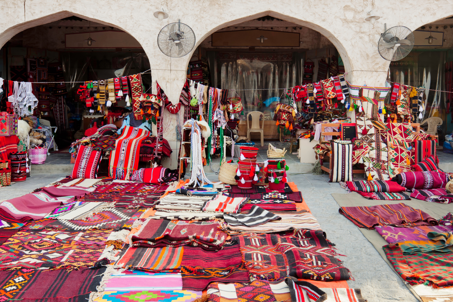 A market filled with lots of colorful rugs and blankets