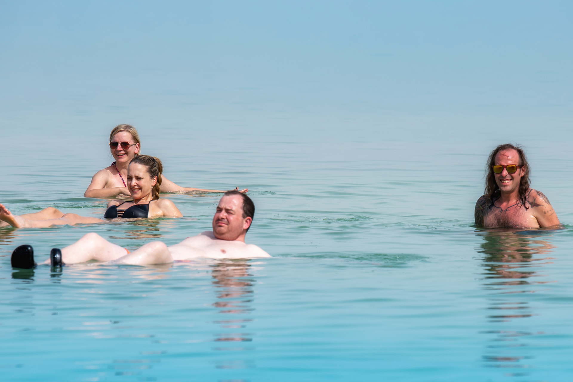 A group of people are floating on their stomachs in the water.