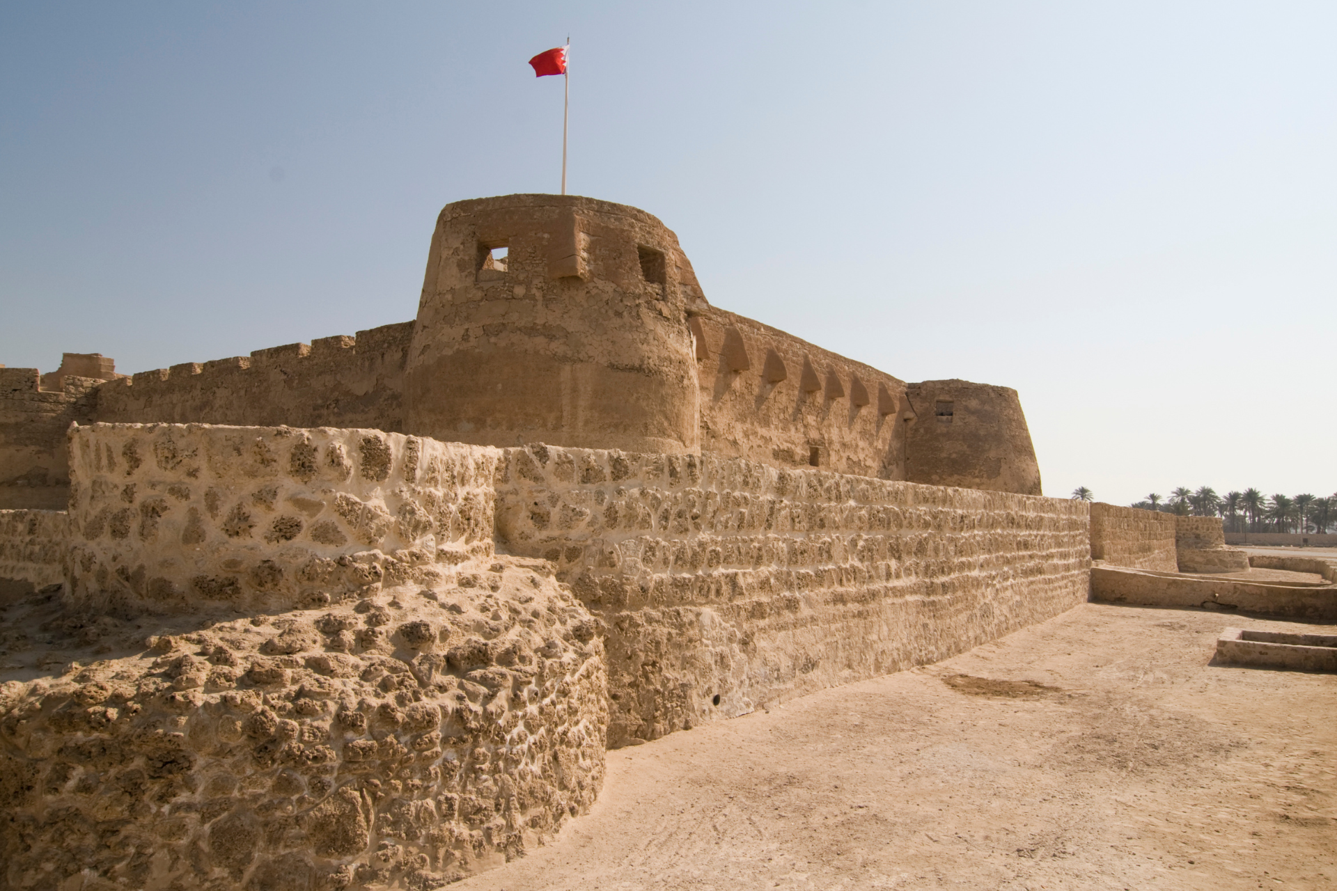 A large stone wall with a red flag on top of it