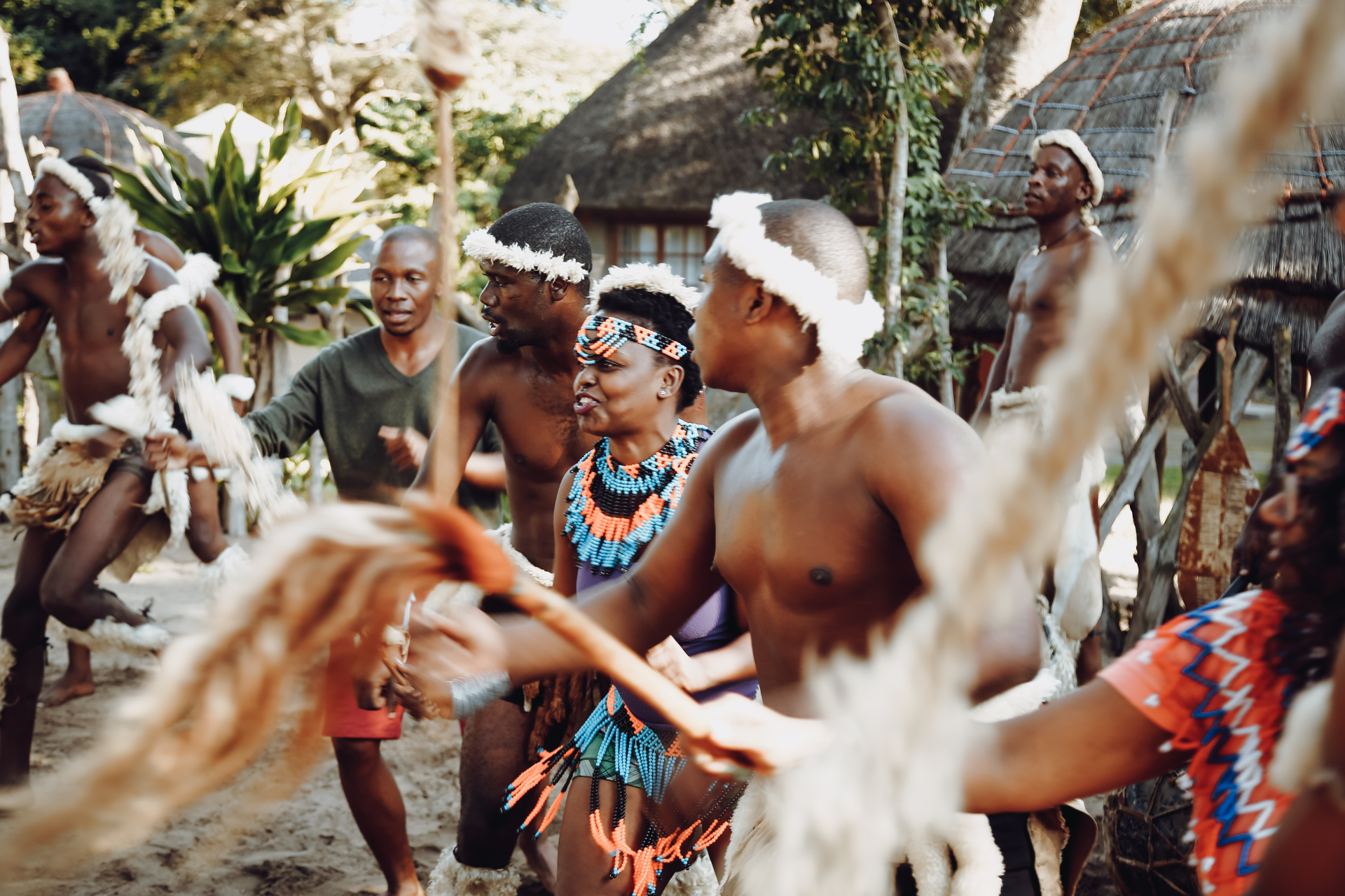 A group of men and women are dancing in a village.