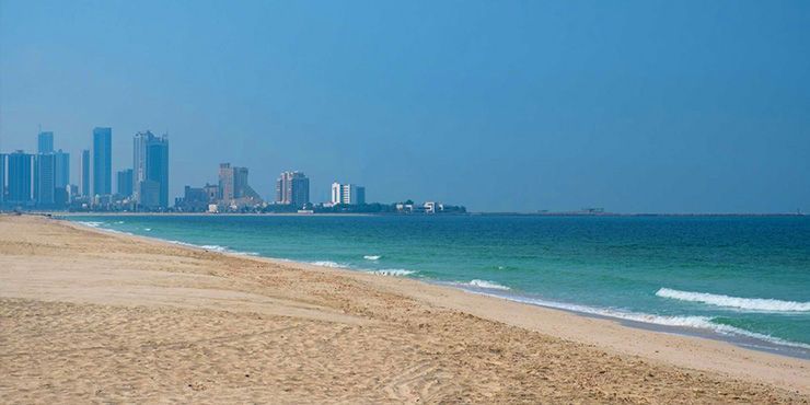 A beach with a city skyline in the background.