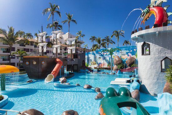 A large swimming pool with a slide and a castle in the background.