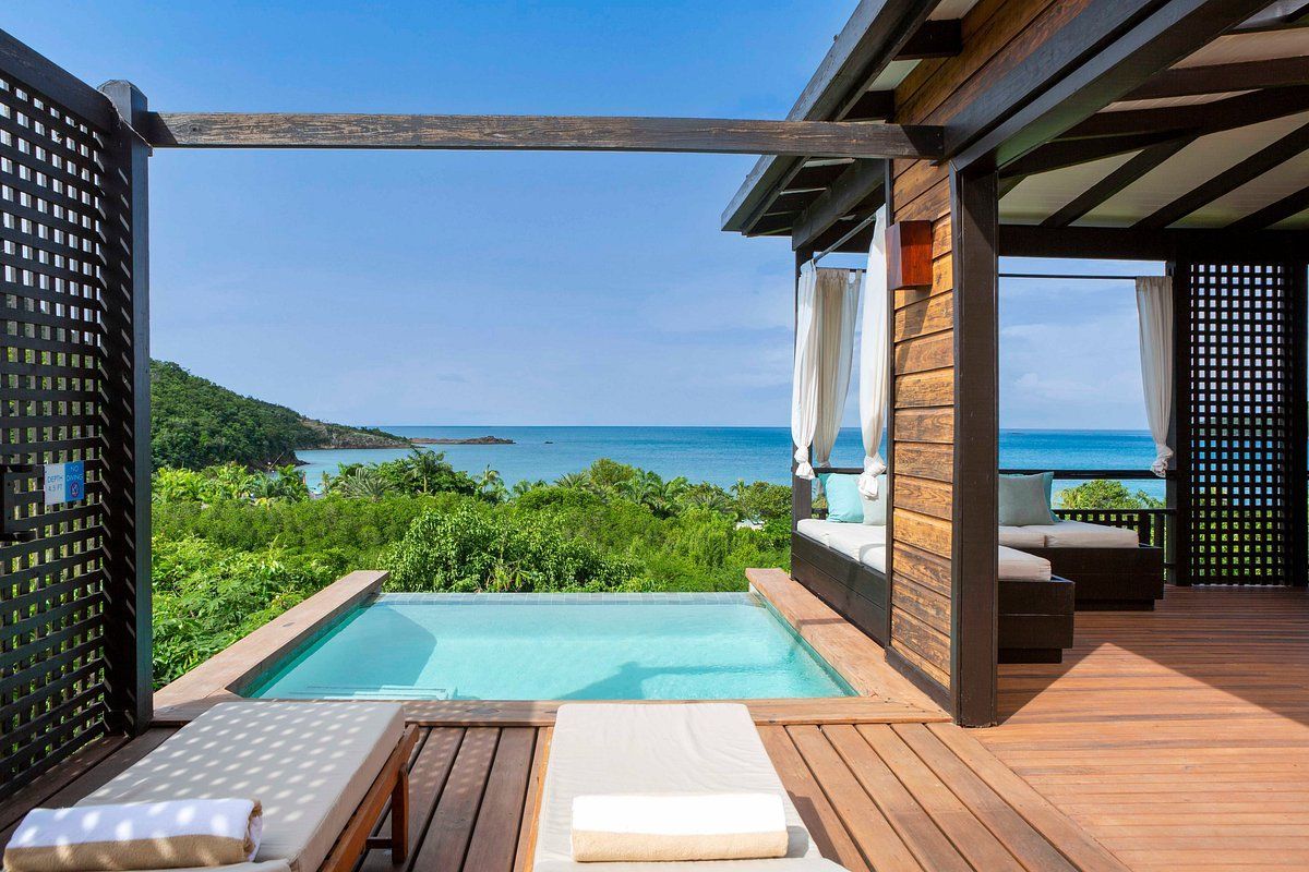 There is a swimming pool on the deck of a house with a view of the ocean.