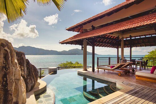 A large house with a swimming pool overlooking the ocean.