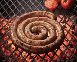 A spiral sausage is cooking on a grill.