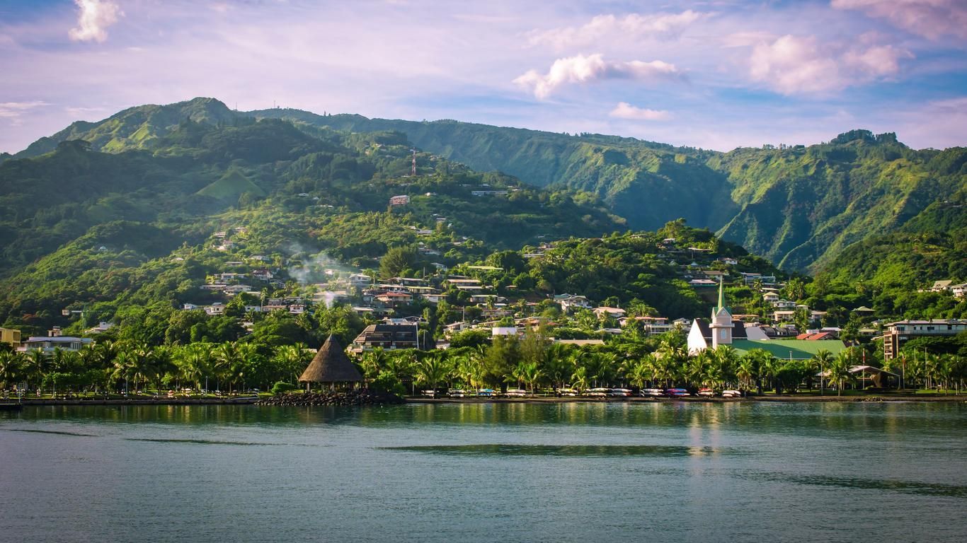 A lake with mountains in the background and a small town in the foreground.