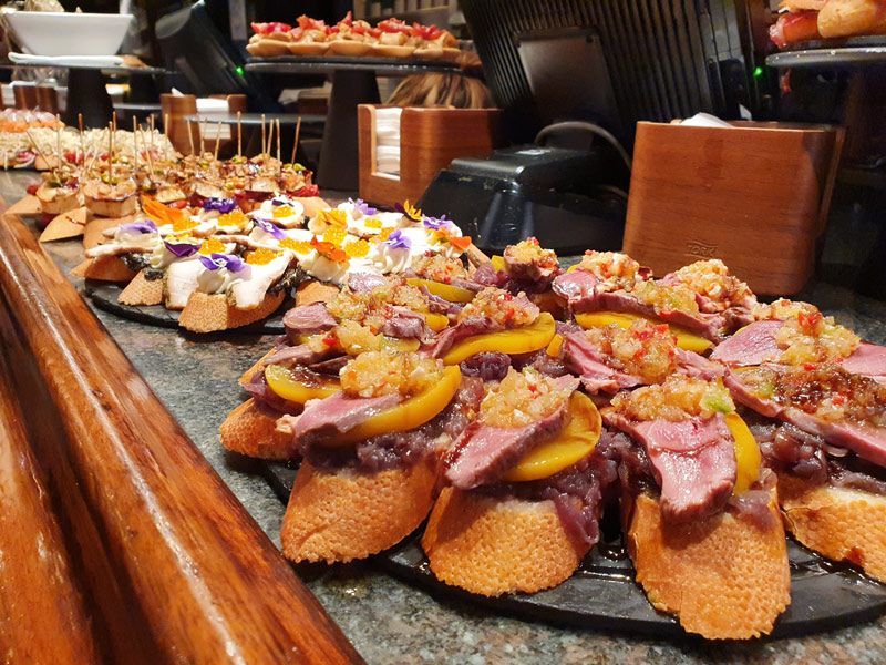 A row of sandwiches are lined up on a counter in a restaurant