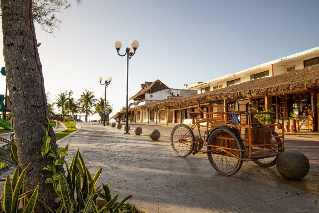 A wooden cart is parked in front of a building.