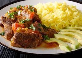 A plate of food with rice and avocado on a table.