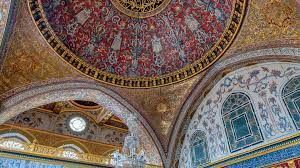 A close up of the ceiling of a building with arches and a dome.