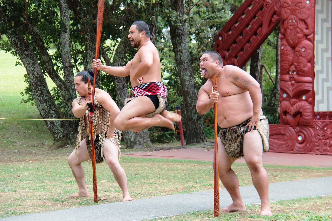 A group of men are jumping in the air while holding poles.