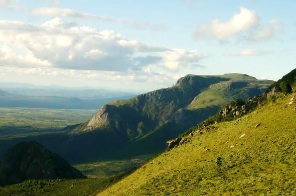 A view of a mountain range from the top of a hill.