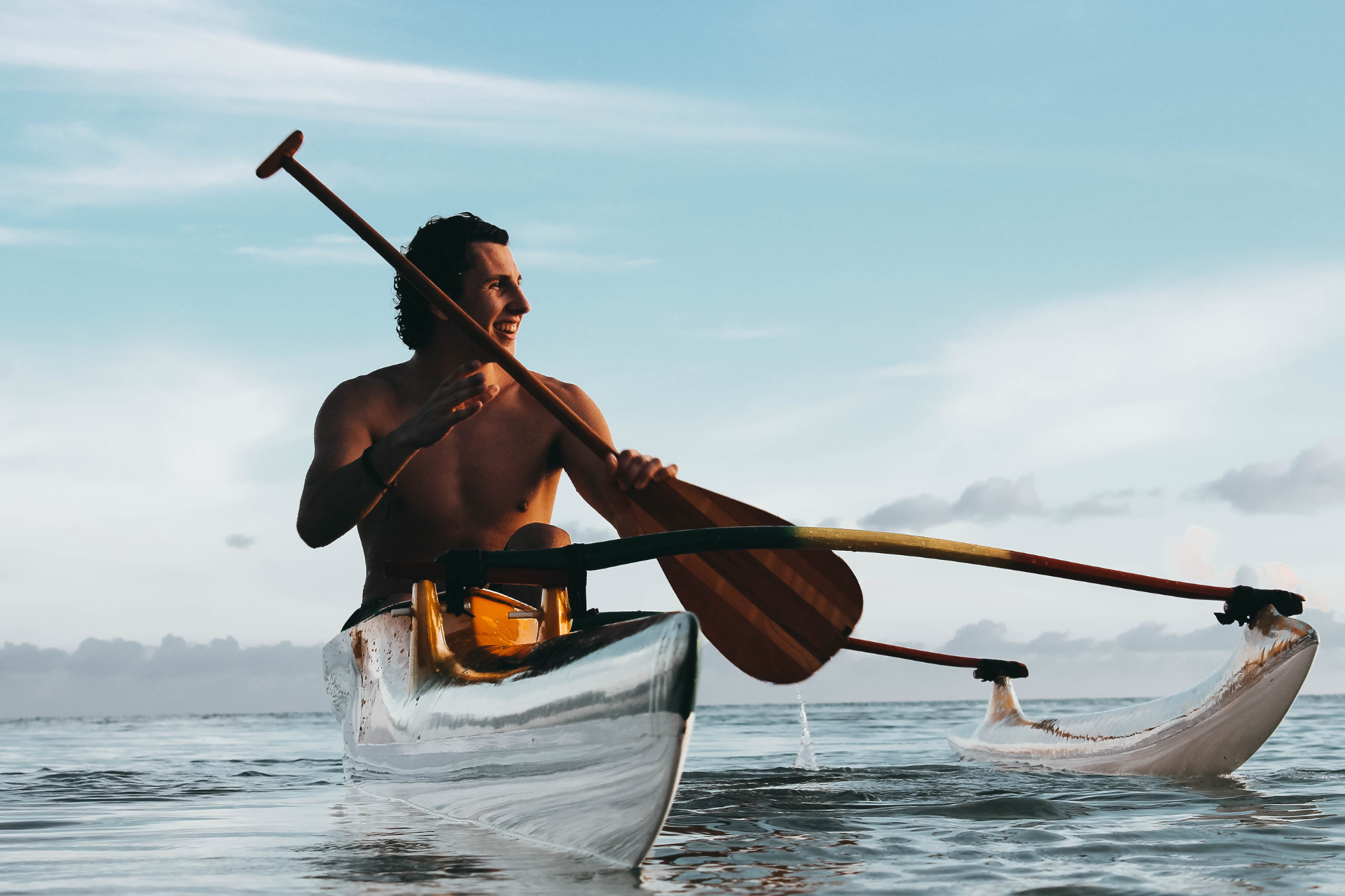 A man is paddling a kayak in the ocean.