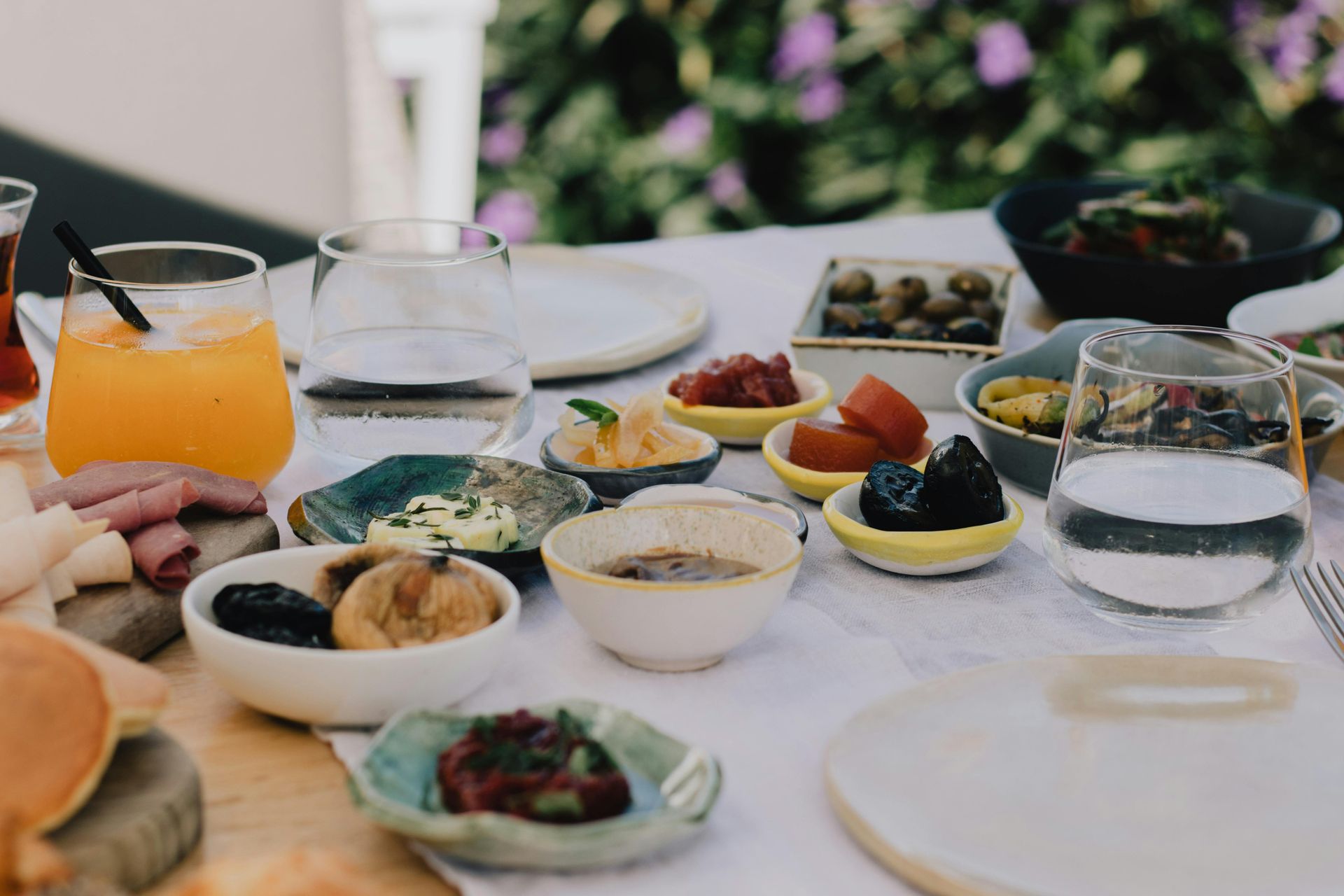 A table topped with plates of food and drinks.