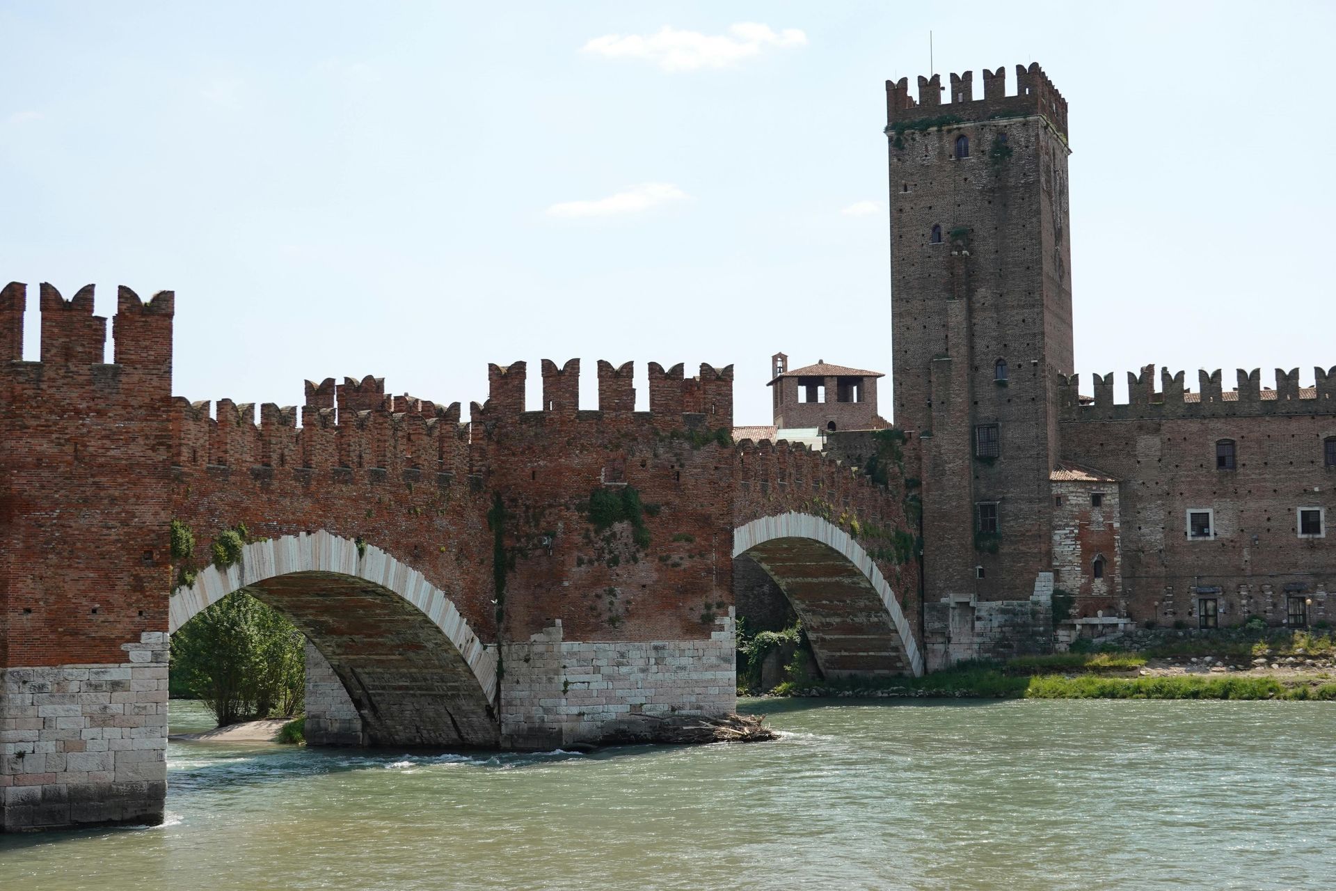 A bridge over a river with a castle in the background