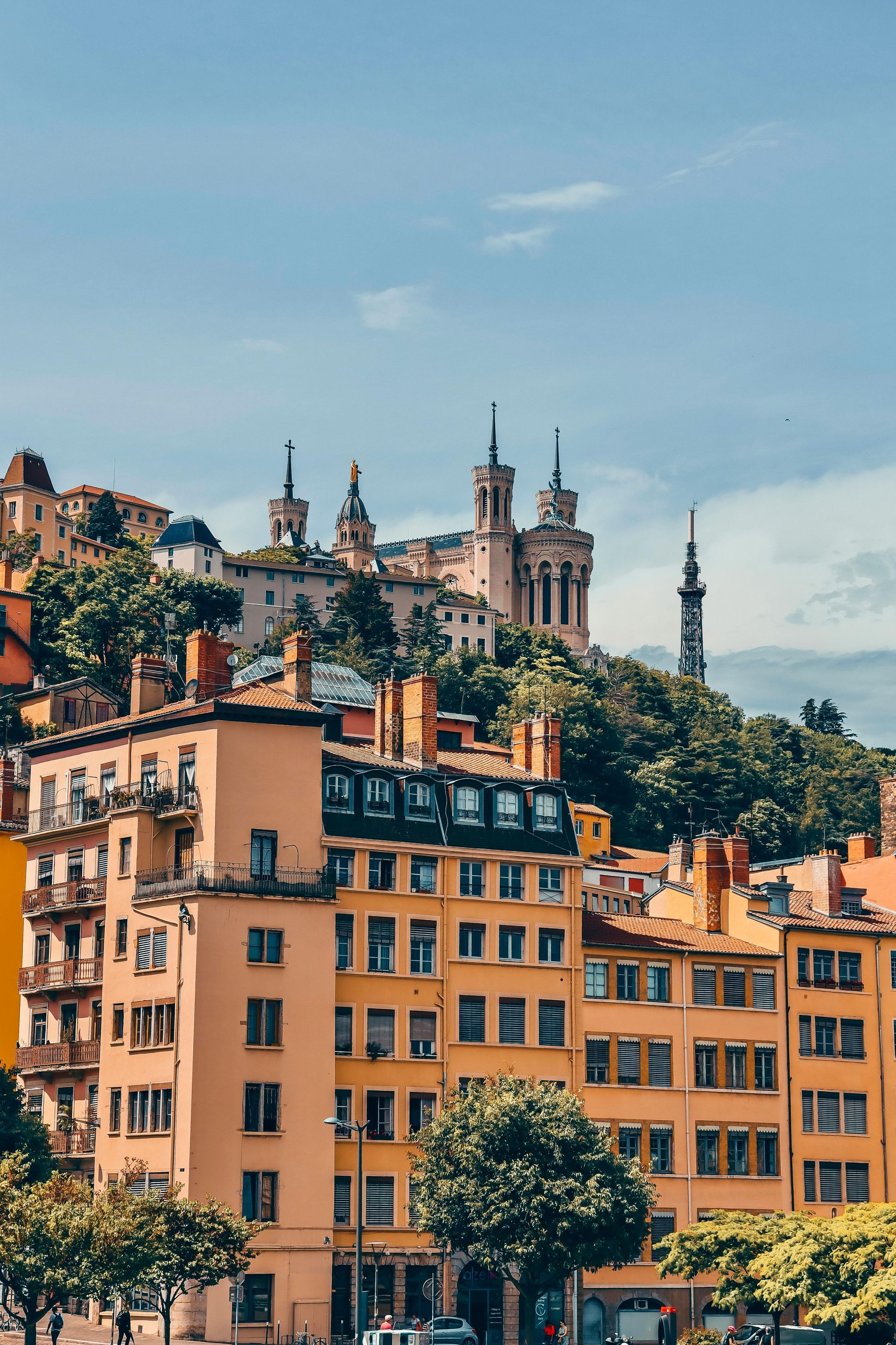 A cityscape with a church on top of a hill in the background.