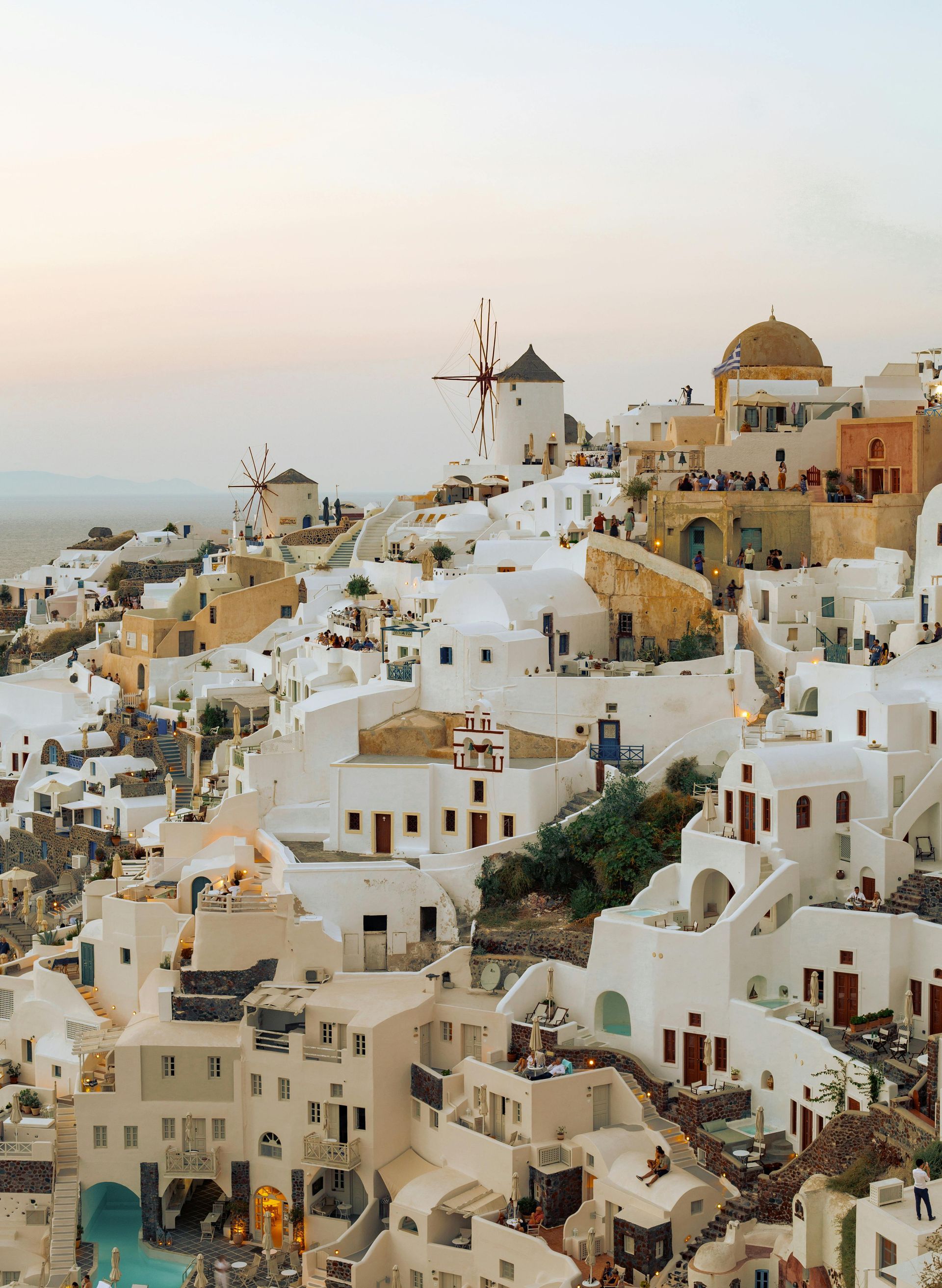 An aerial view of a city with white buildings and a windmill.