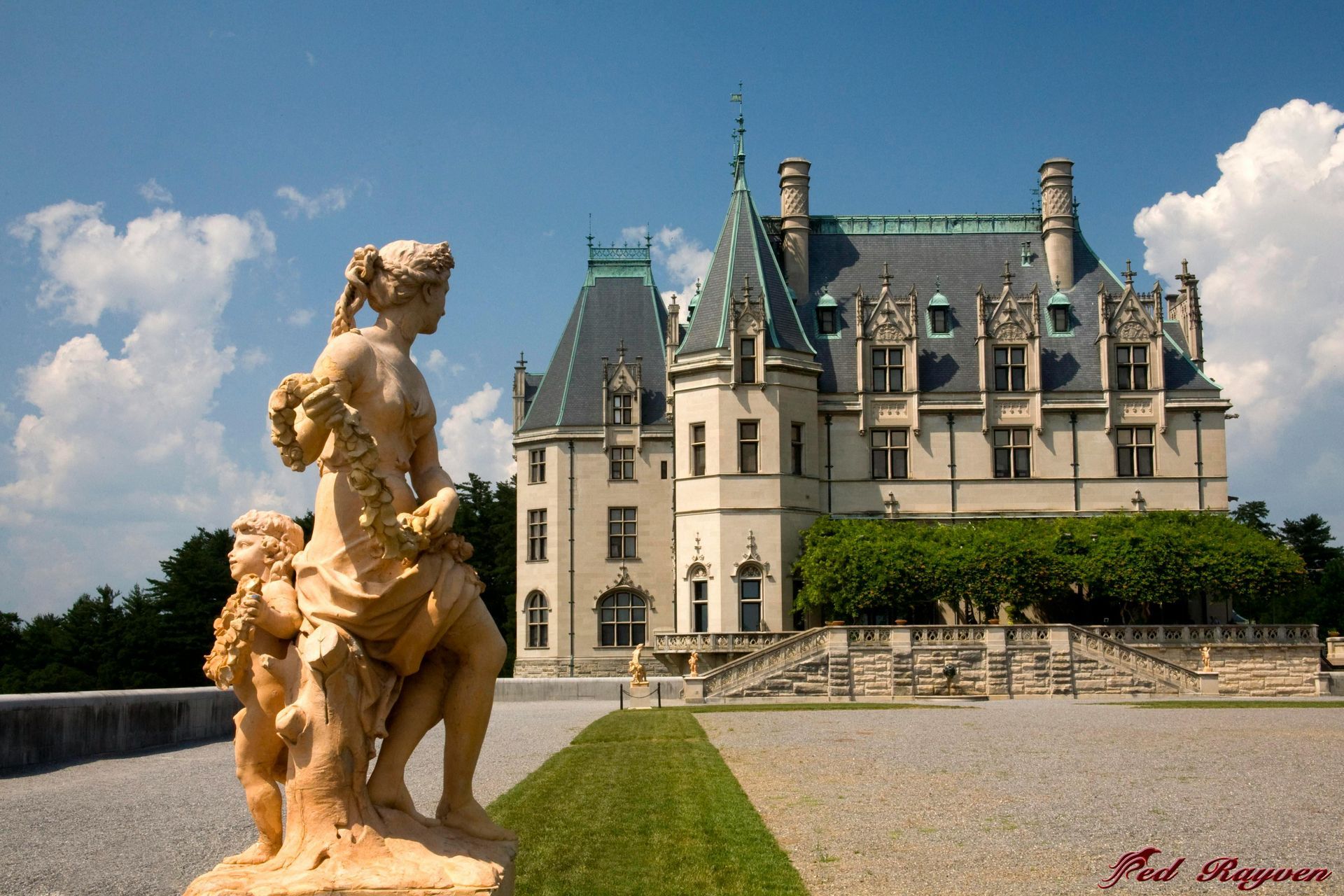 A large castle with a statue in front of it