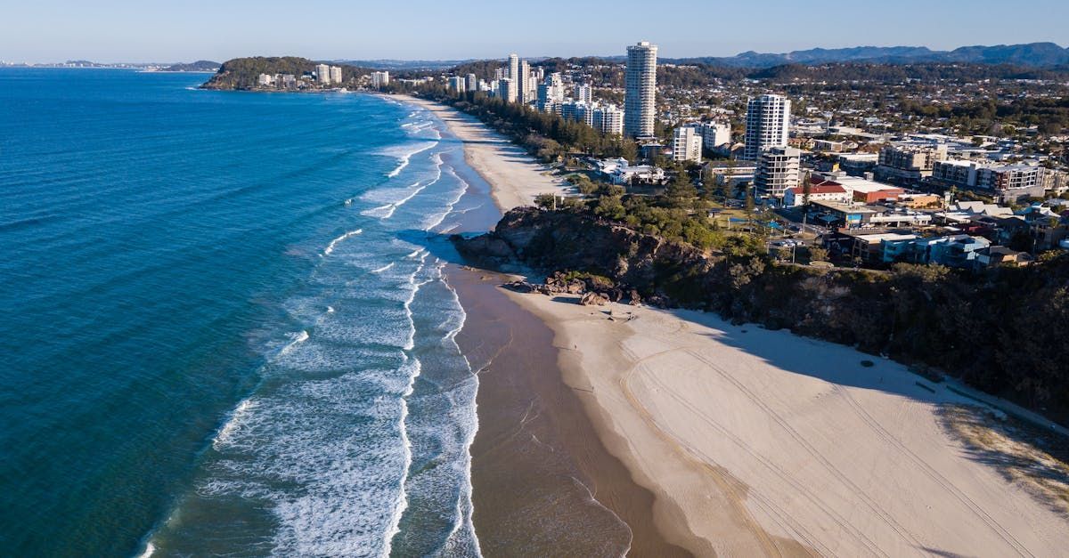 An aerial view of a beach with a city in the background.