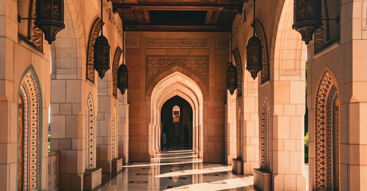 A long hallway in a building with arches and lanterns.