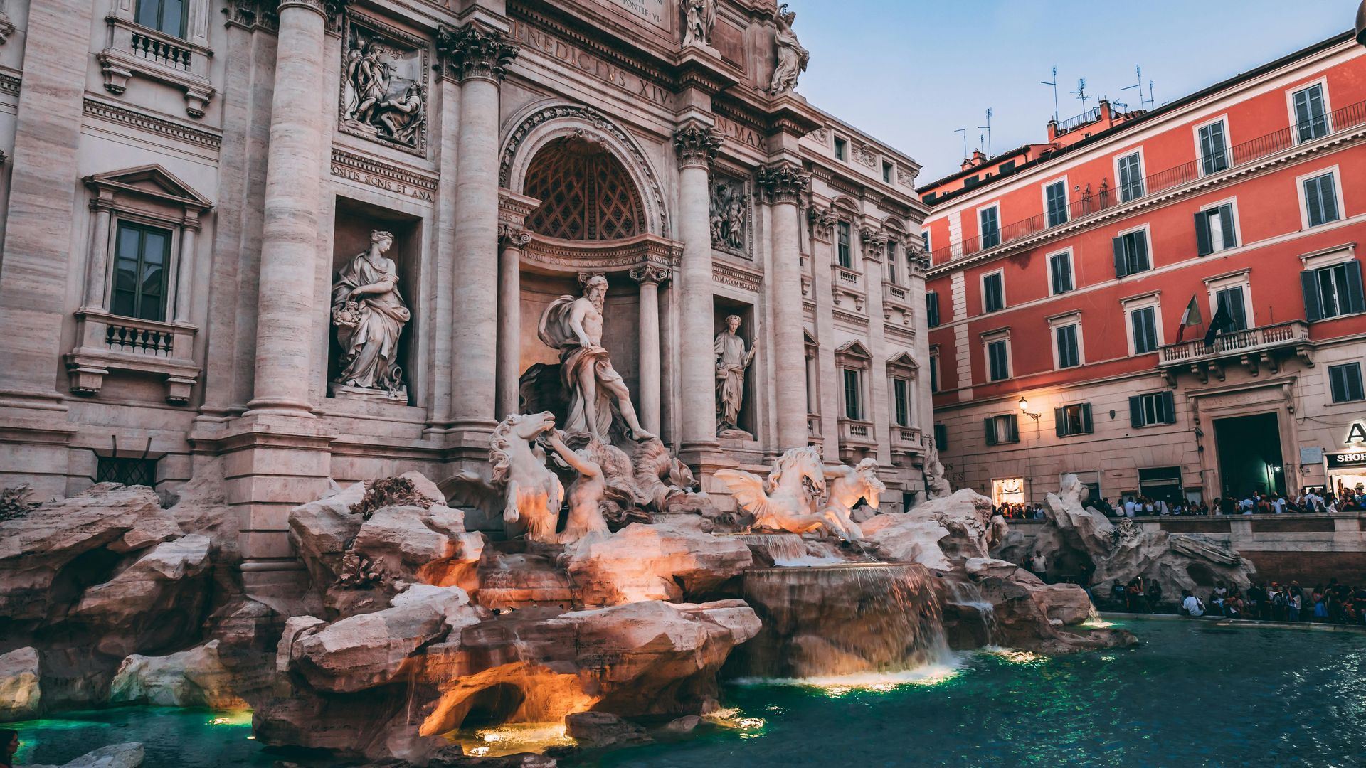 There is a fountain in front of a building in rome.