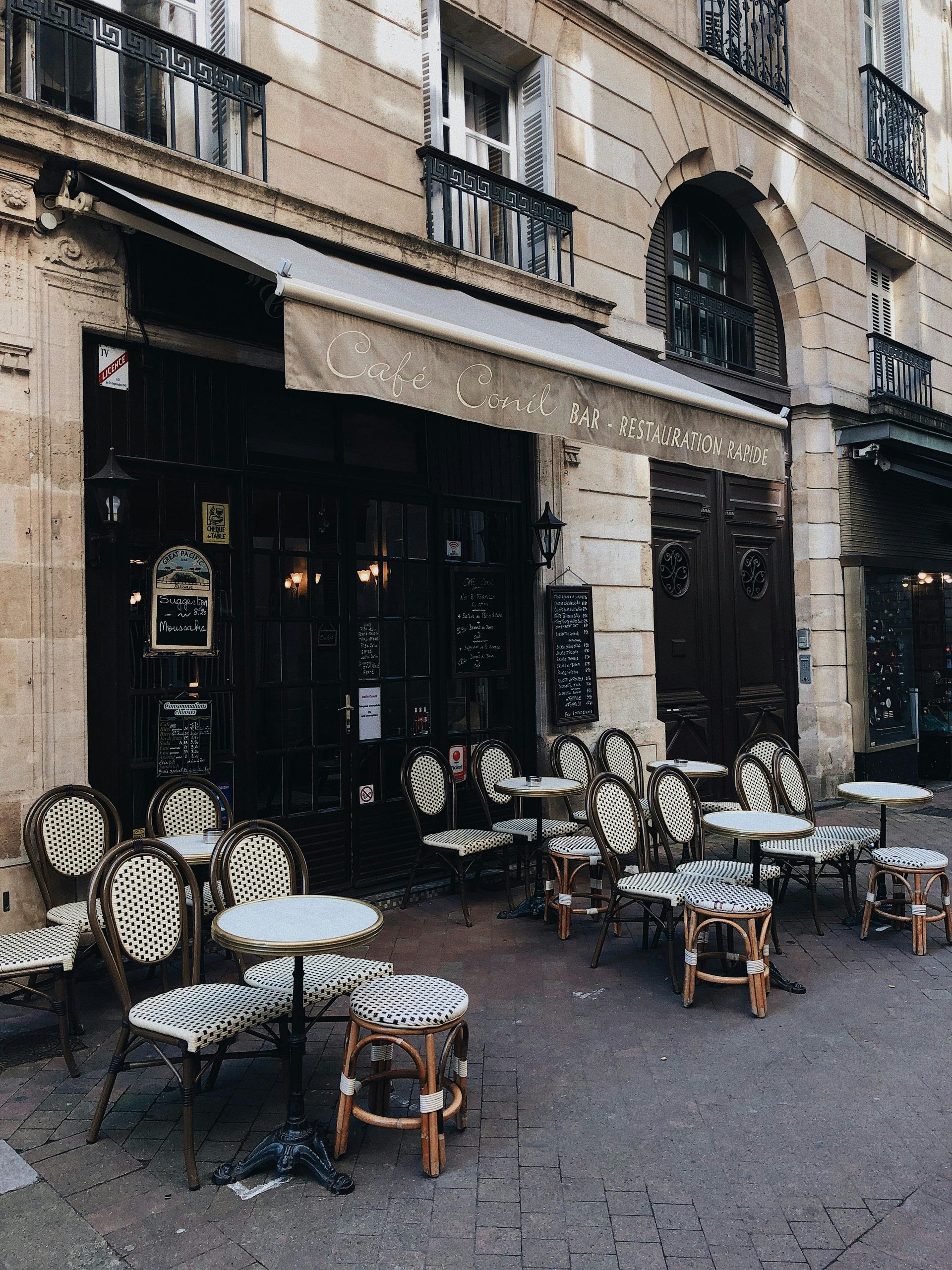 A restaurant with tables and chairs outside of it